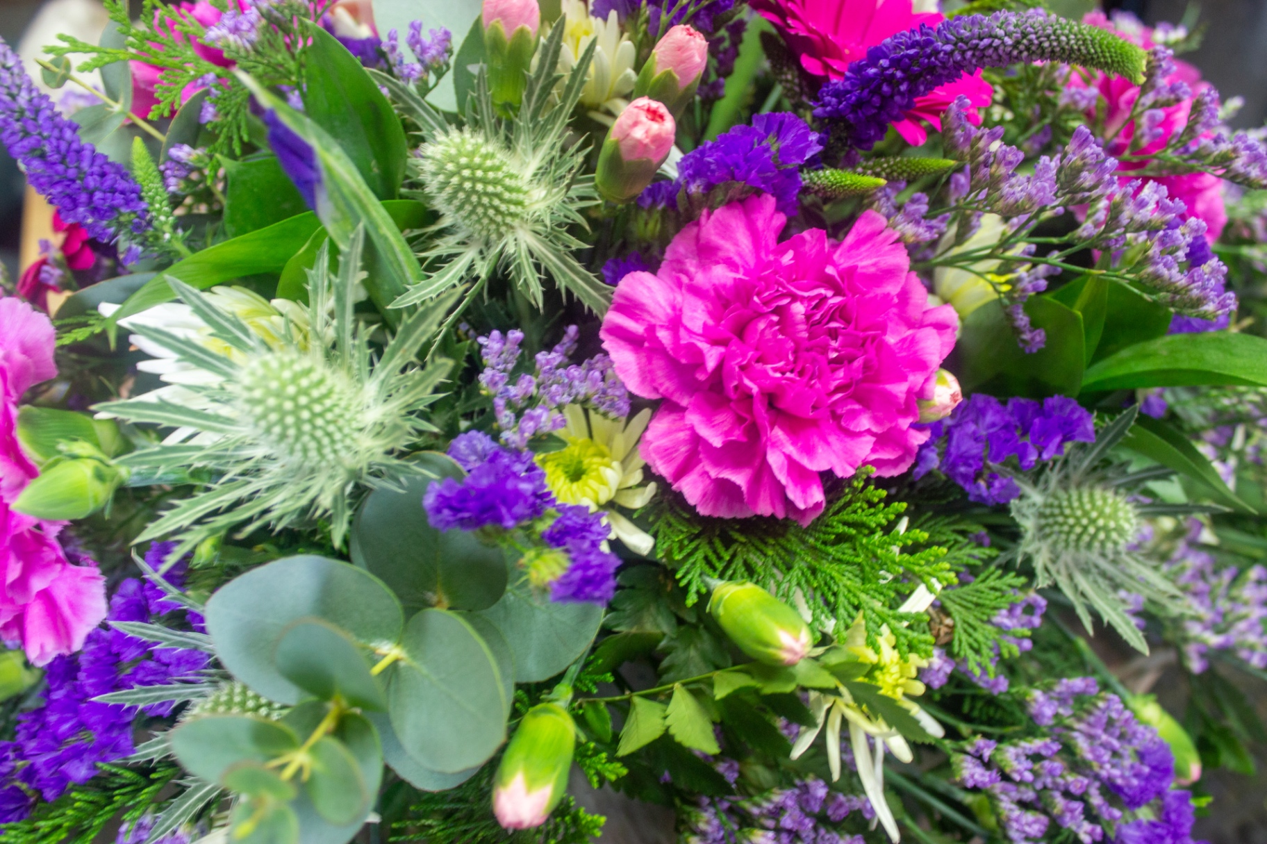 Mixed bouquet of pink carnations, purple statice and eucalyptus photographed at Flowers by Alison